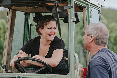 Wine campus student in tractor talking to her boss