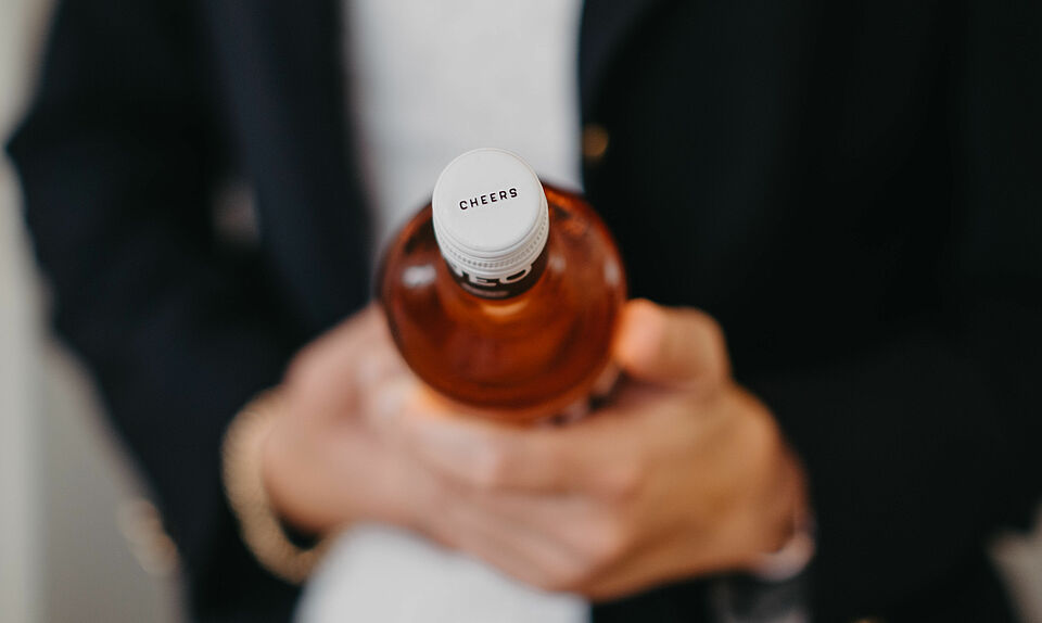 woman with wine bottle cheers