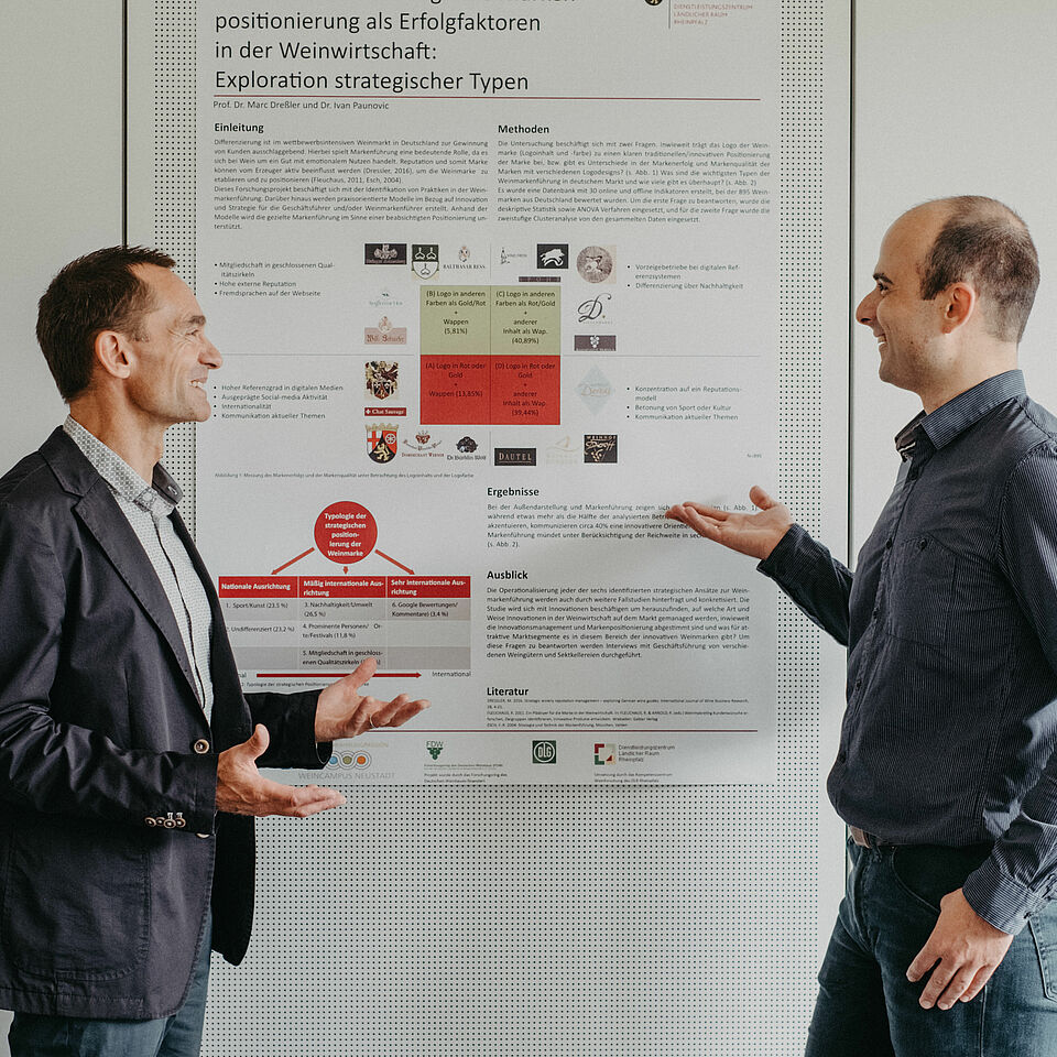 Prof. Dr. Marc Dreßler in front of a flip chart talking to a conversation partner