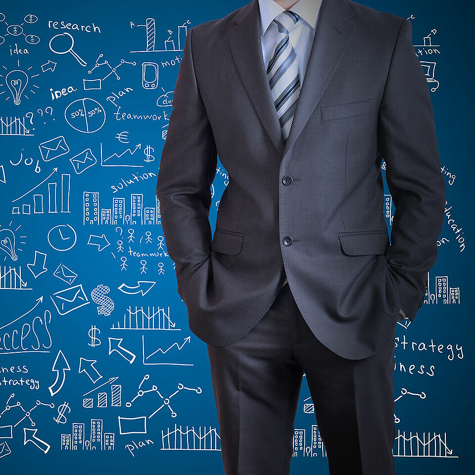 man in suit on front of blue wall