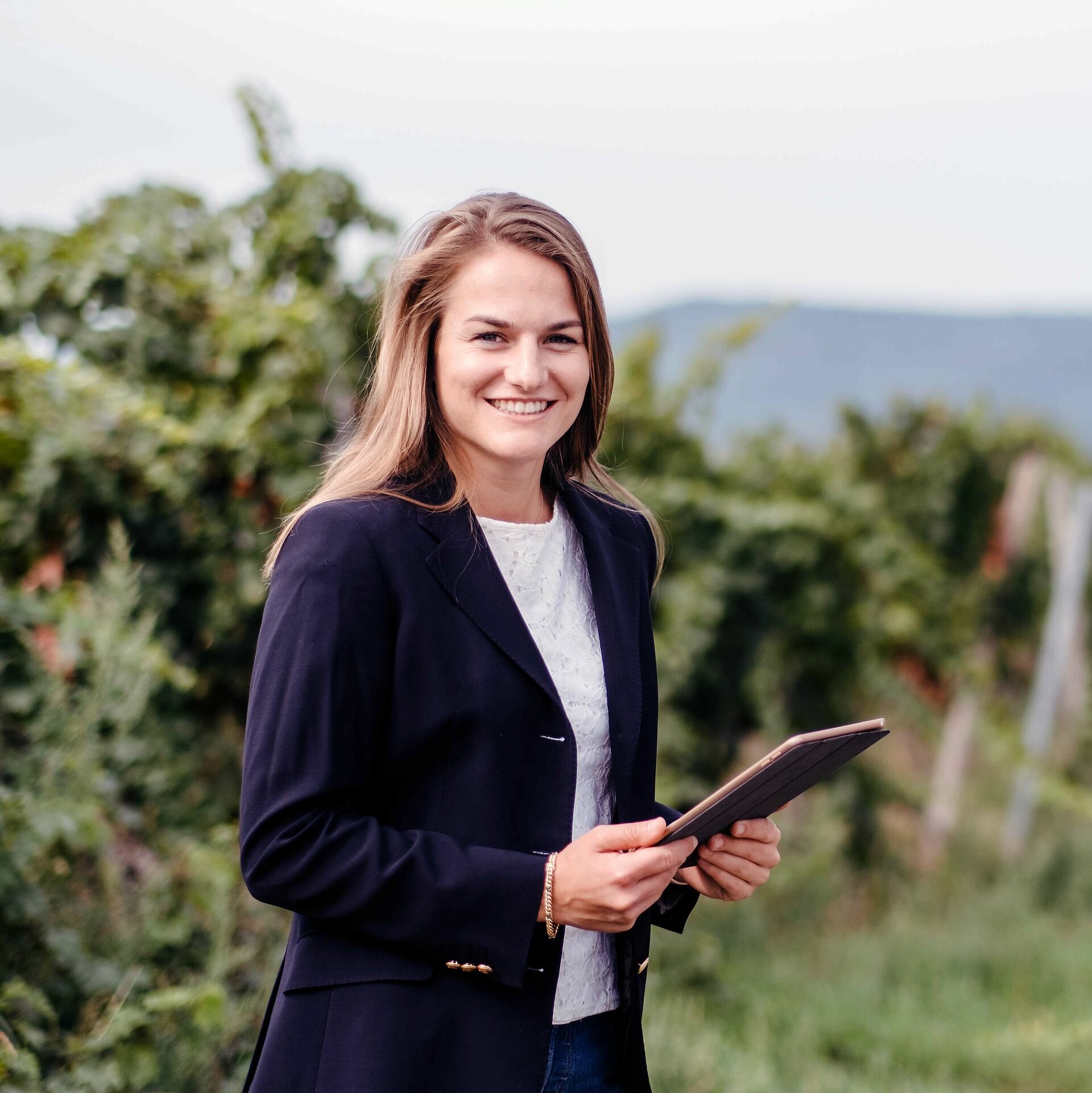 Une étudiante avec une tablette dans les vignes