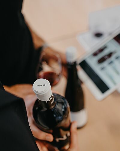 Bouteille de vin au premier plan et tablette floue à l'arrière-plan