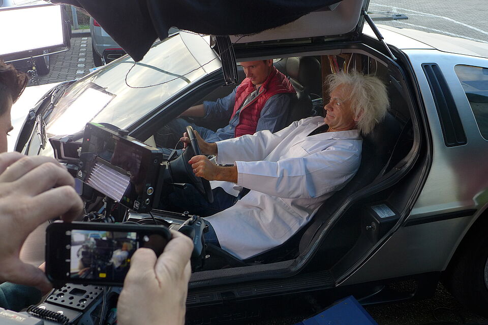 zwei Schauspieler in altem Auto am Set