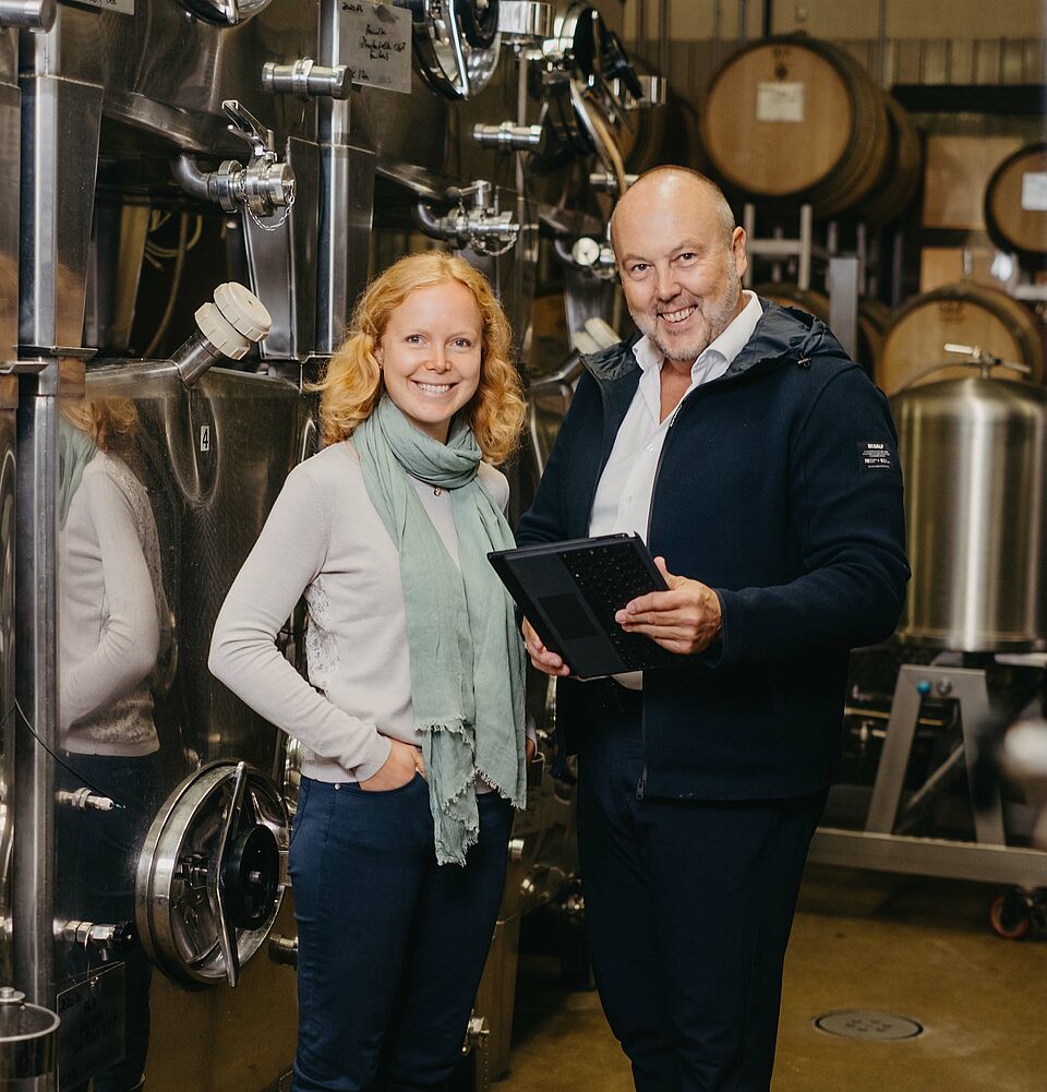 man and woman stand in wine cellar